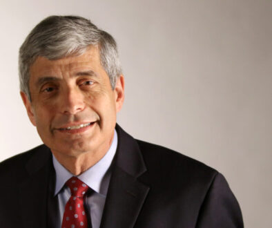 A man in suit and tie smiling for the camera.
