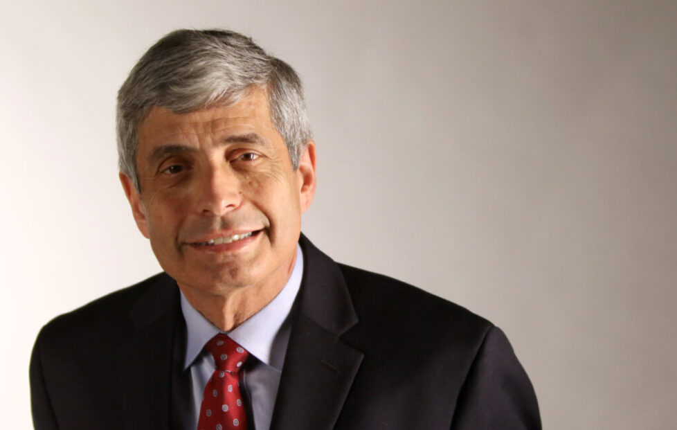 A man in suit and tie smiling for the camera.